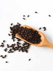 Top view of fetid cassia seed also called ketsumei-shi on wooden spoons isolated on a white background. Asia traditional Chinese medicine. Good for the eyes. .Cassia herb Tea. With copy space.