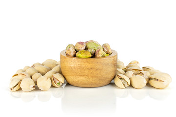 Lot of whole ripe green pistachio in tiny wooden bowl isolated on white background