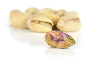 Lot of whole ripe green pistachio one is without shell in closeup isolated on white background