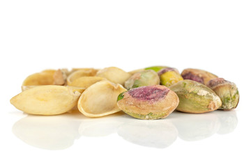 Fototapeta premium Lot of whole lot of pieces of ripe green pistachio isolated on white background