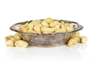 Lot of whole unsalted beige cashew in metal bowl isolated on white background