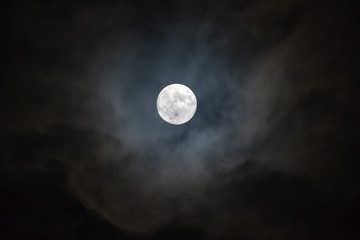  Full moon on the dark night shining on the sky in cloudy day.