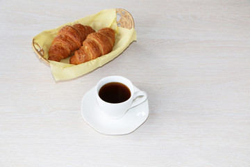Close-up - breakfast, cup of coffee and croissants.