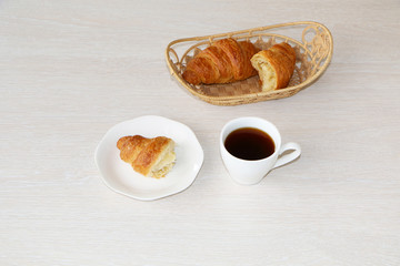 Close-up - breakfast, cup of coffee and croissants.