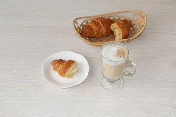 Close-up - breakfast, cup of coffee and croissants.