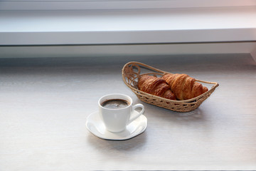 Close-up - breakfast, cup of coffee and croissants.