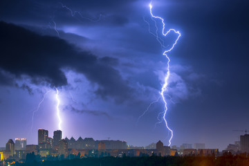Lightning storm over the city at the summer heavy rain. Dramatic, breathtaking atmospheric natural...