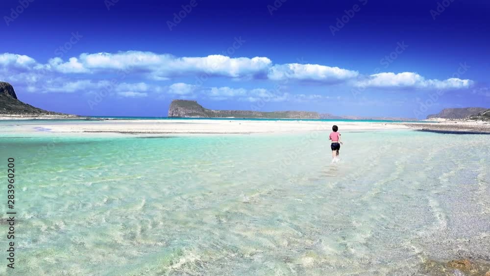 Wall mural Boy running in water at beach