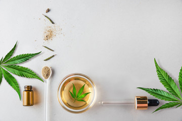 Glass green bottle and pipette with CBD oil and cannabis leaf on background. Minimal concept. Flat...