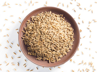 Cumin seeds (Cuminum), Jeera in a clay plate on a white background