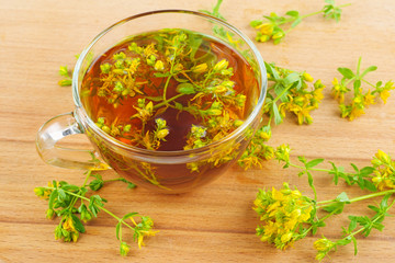 St. John's wort and herbal tea isolated on wooden background