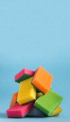 on a blue background there is a lies a mountain of sponges for washing dishes