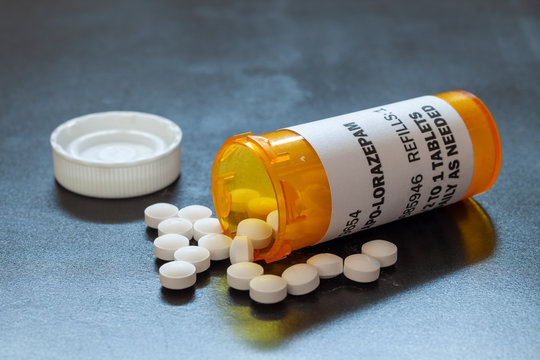 Prescription bottle with backlit Lorezapam tablets. Lorezapam is a generic prescription anti-anxiety medication. A concept for mental health.