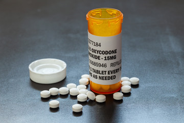 Prescription bottle with backlit Oxycodone tablets. Oxycodone is a generic prescription opioid. A concept of the opioid epidemic crisis