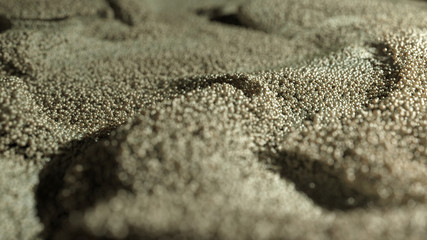 Golden Glitter Dust background. Golden pearls. Yellow loosened sand on ground.