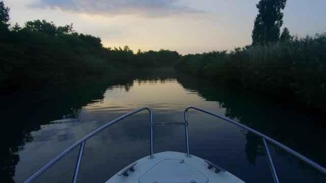Boat cruising in a canal of the Grado Lagoon, Italy