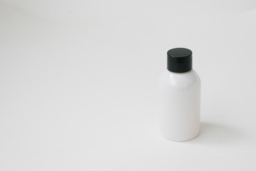 Cosmetic white bottle on white background. Cosmetic packaging for the collection of creams, oils, balms, shampoos. Copy space