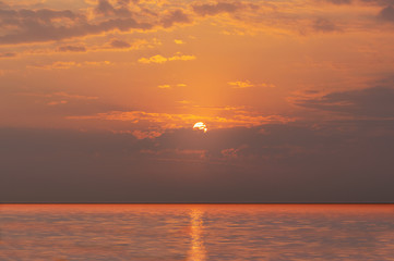 Bright sunset with  yellow sun under the sea, Sky background on sunset. Nature composition.