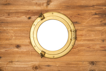 Vintage brass porthole in wooden wall, window isolated with clipping path