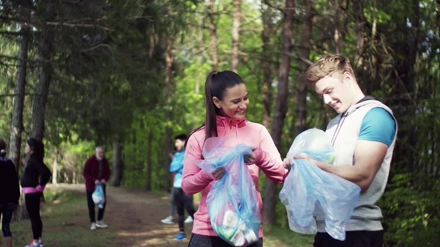 Group of fit people picking up litter in nature, a plogging concept.