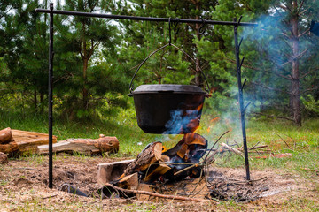 fish soup cooked on a bonfire in a fishing pot