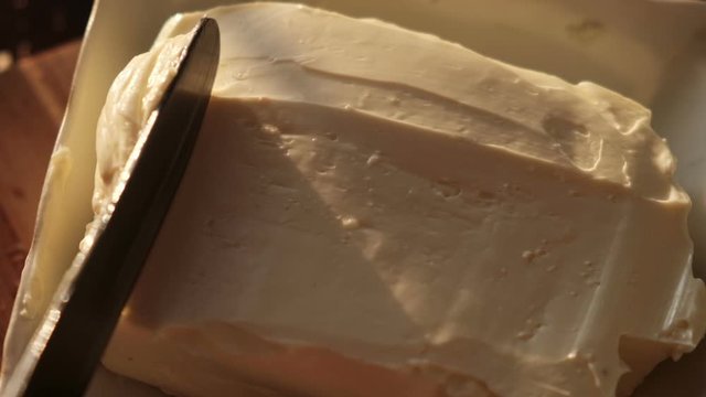 Cheese butter or margarine with knife, close up slow motion