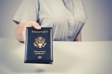 Immigration and passport control at the airport. woman border control officer with US passport of american citizen. Concept