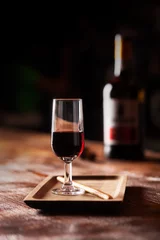 Fotobehang Glass of port wine on wooden table and over dark background © zakiroff
