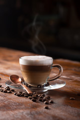 Cup of coffe with milk on a dark background. Hot latte or Cappuccino prepared with milk