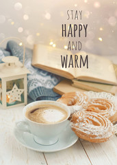 Stay Happy and warm - motivation inspiration quote. cozy home comfort. coffee cup, books, cookie. autumn winter breakfast. hygge concept. soft focus