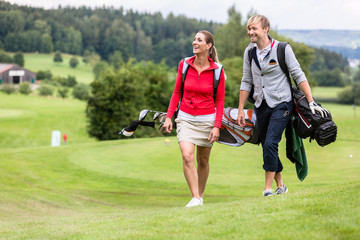 Fototapeta premium Golfing couple walking together on golf course