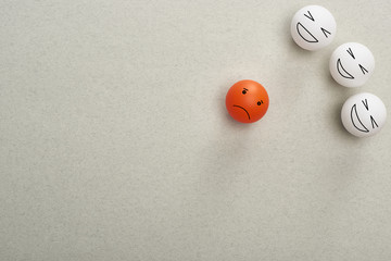 top view of balls with cruel and sad face expressions symbolizing victim and abusers on grey background