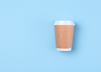 Cup of coffee to go on blue pastel flat lay