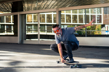 Skater riding a skateboard. Skater with beard and tattoo