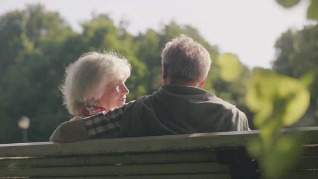 Back view of old couple sitting on bench