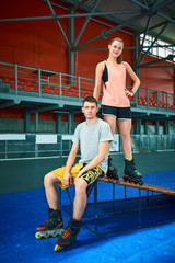 Girl and boy on rollerblades in skate park