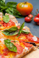 Pie with tomatoes and basil cut into pieces