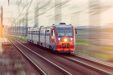 Passenger diesel train travels by rail motion blur effect.