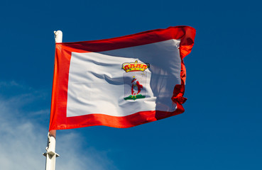 National flag of Gijon on flagpole over the sky, Asturias, Spain