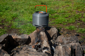 Kettle with a mug in a tourist camp. outdoor recreation in the Carpathian forest..