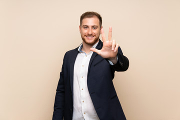 Blonde man over isolated background happy and counting three with fingers