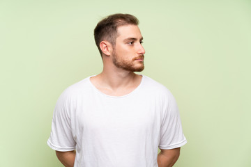 Fototapeta premium Handsome man over green background looking side
