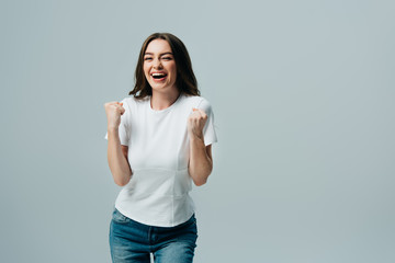 excited happy beautiful girl in white t-shirt showing yes gesture isolated on grey
