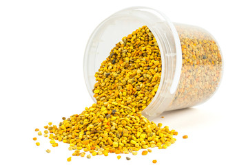 bee pollen granules in small plastic container isolated on white background