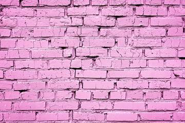 Close-up of a brick cracked wall of bright trendy pink color.