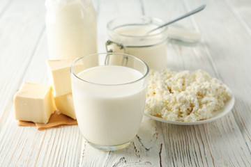 Different dairy products on white wooden background, space for text