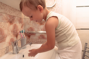 Obraz na płótnie Canvas Boy wash the face in the bathroom.The beginning of a new day