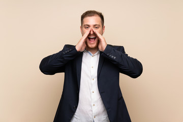 Blonde man over isolated background shouting and announcing something