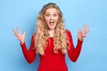 Young beautiful girl with raised arms being shocked by huge, big sales. close up portrait, isolated...