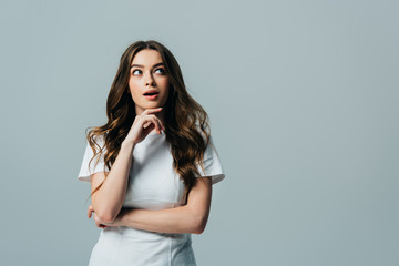 beautiful girl with open mouth looking away in white t-shirt isolated on grey